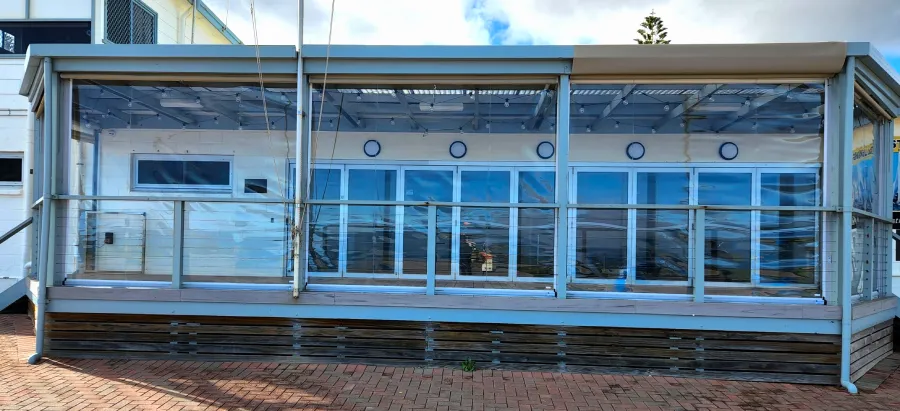 Beachside cafe with clear protective blinds